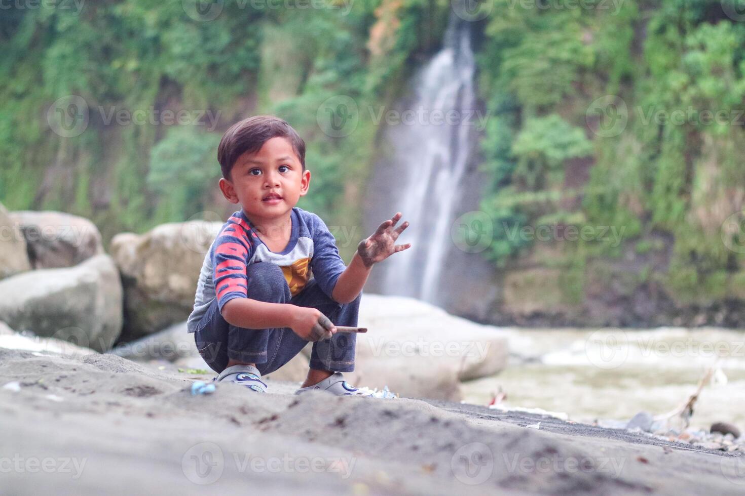 Asian child boy playing toys and sand with natural background. Fine motor skills development for little child. Soft focus. Copy space. photo