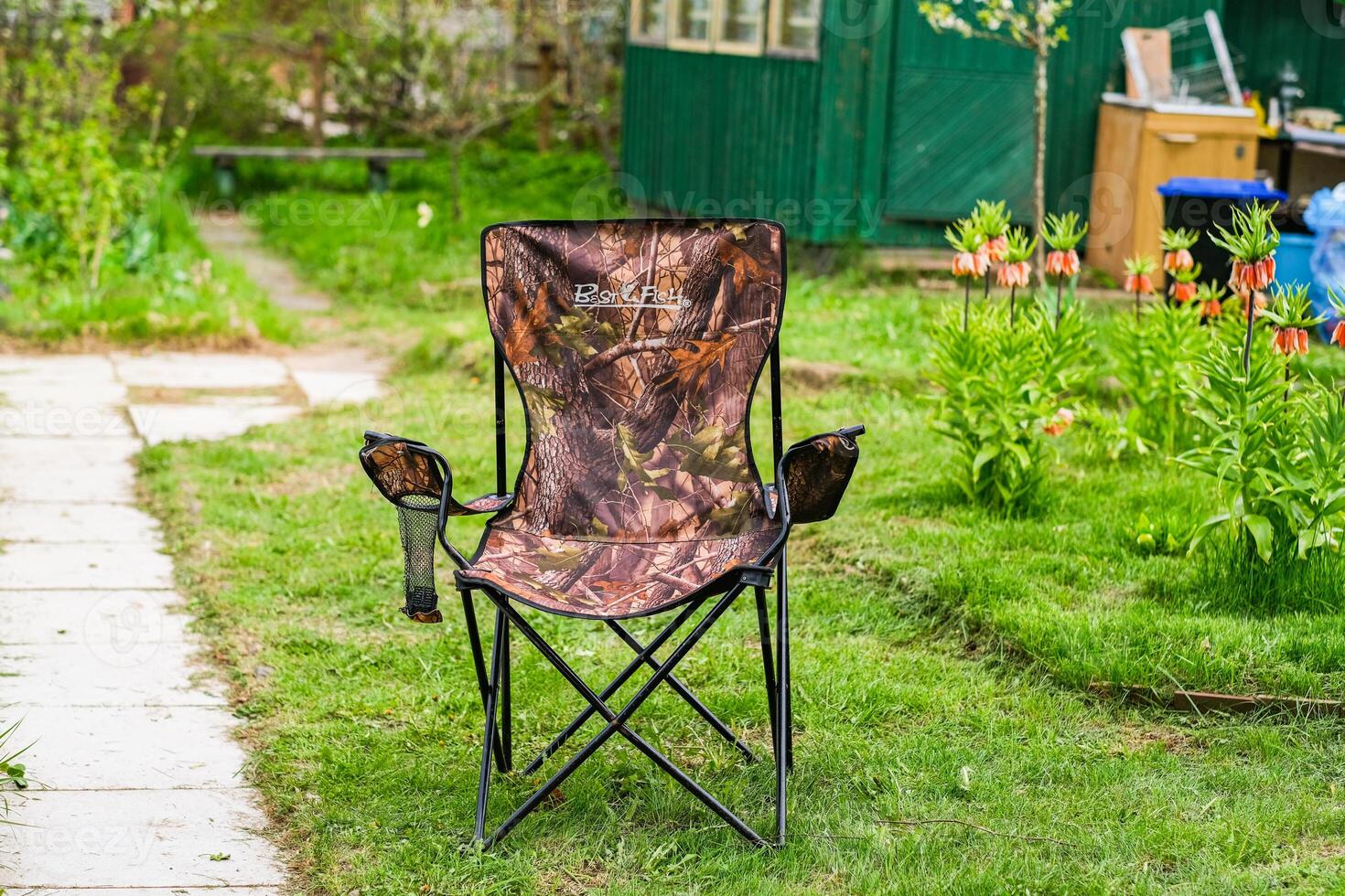 moscow, russia, 10.05.2025 A brown chair with a camouflage print sits in a grassy yard photo