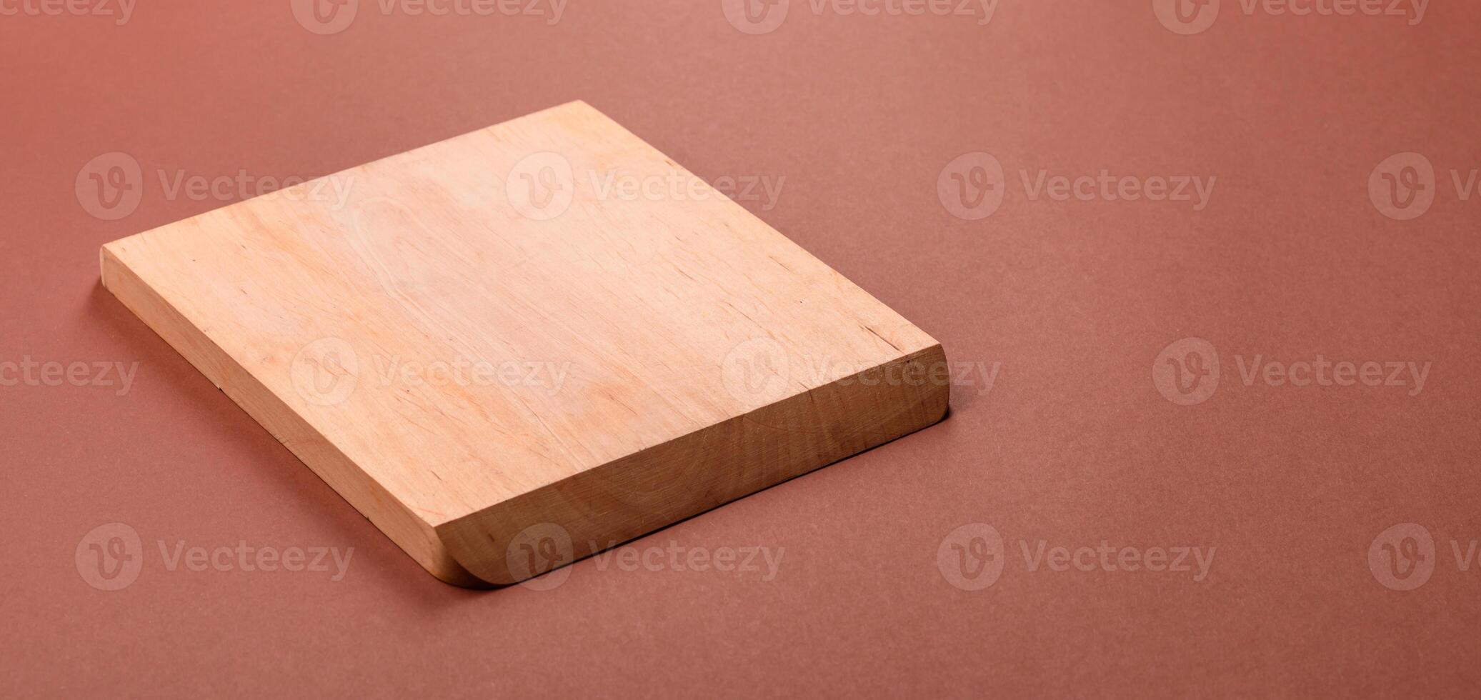 Empty wooden cutting board on brown background photo