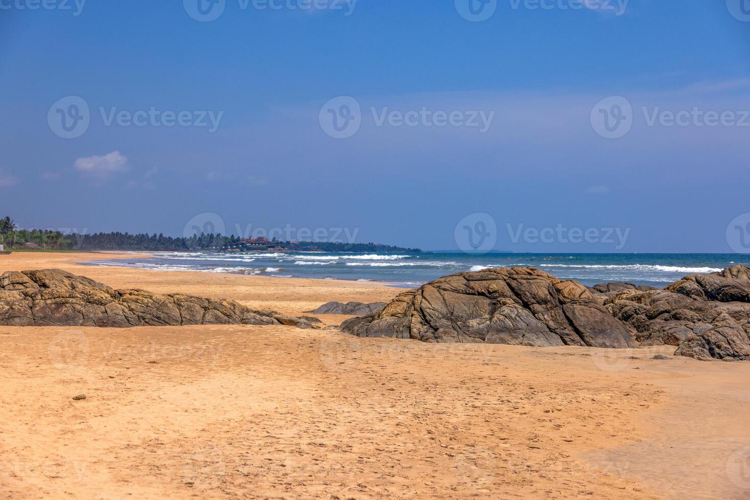 Sunny tropical beach with rocks and turquoise ocean in Sri Lanka 1 photo
