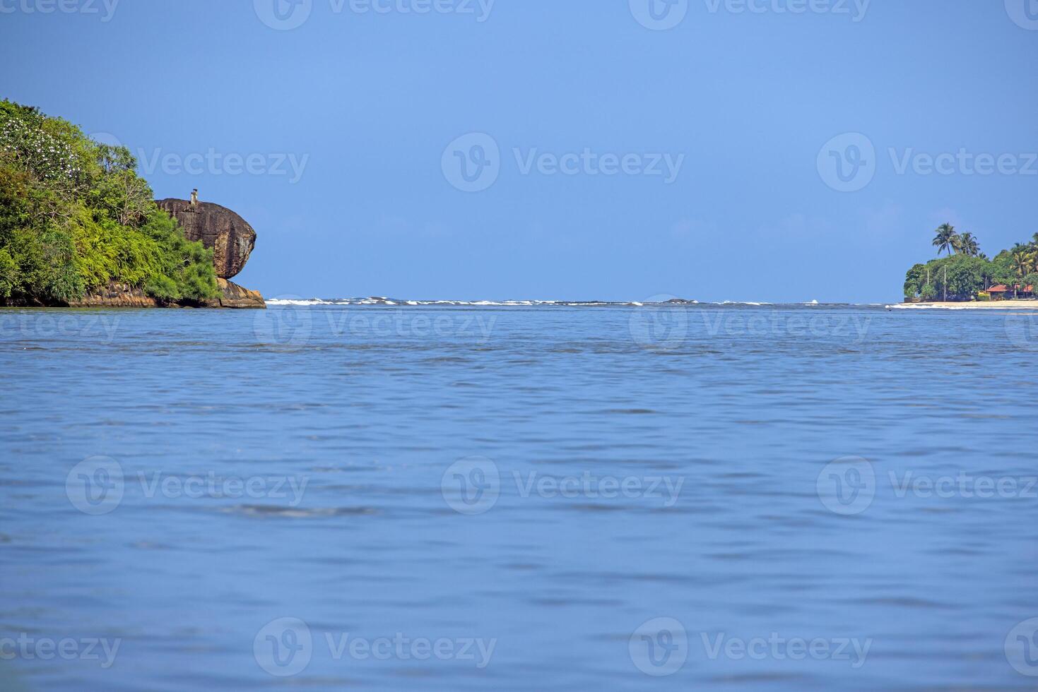 Calm sea view with green cliff and bright blue sky photo