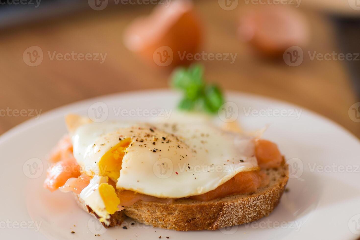 A delicious simple breakfast. A slice of bread with a cooked egg and lightly salted red fish photo