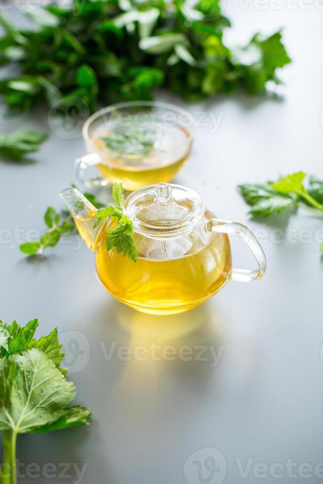 Green tea from currant leaves and mint in a glass container photo