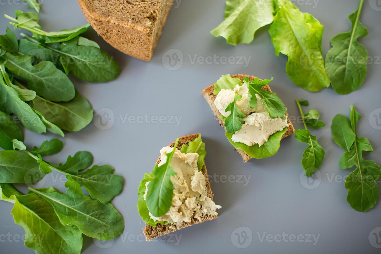 Sandwich with herring paste and greens on a gray background. Simple breakfast. photo