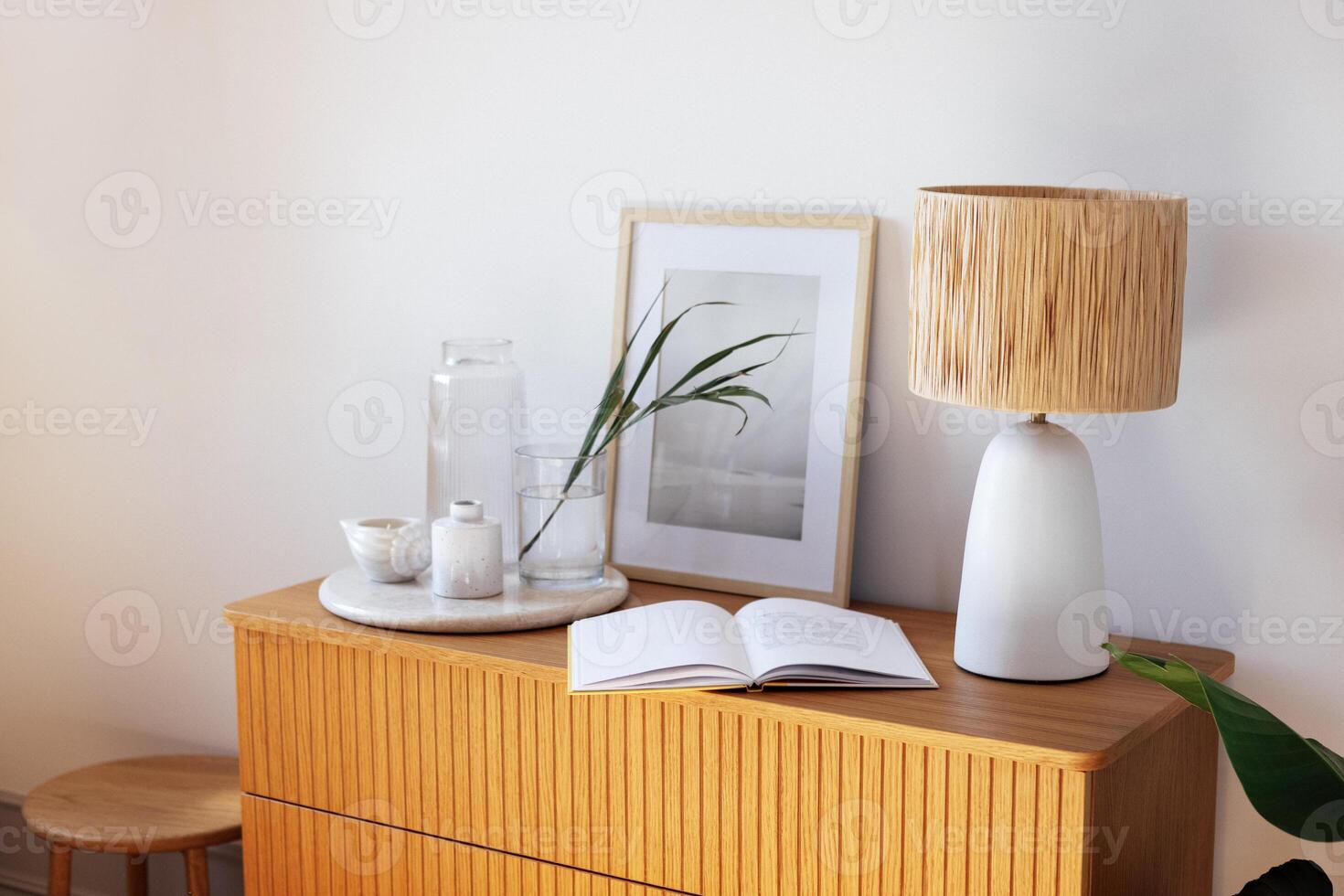 A wooden chest of drawers in the bedroom and an open window with louvered shutters photo