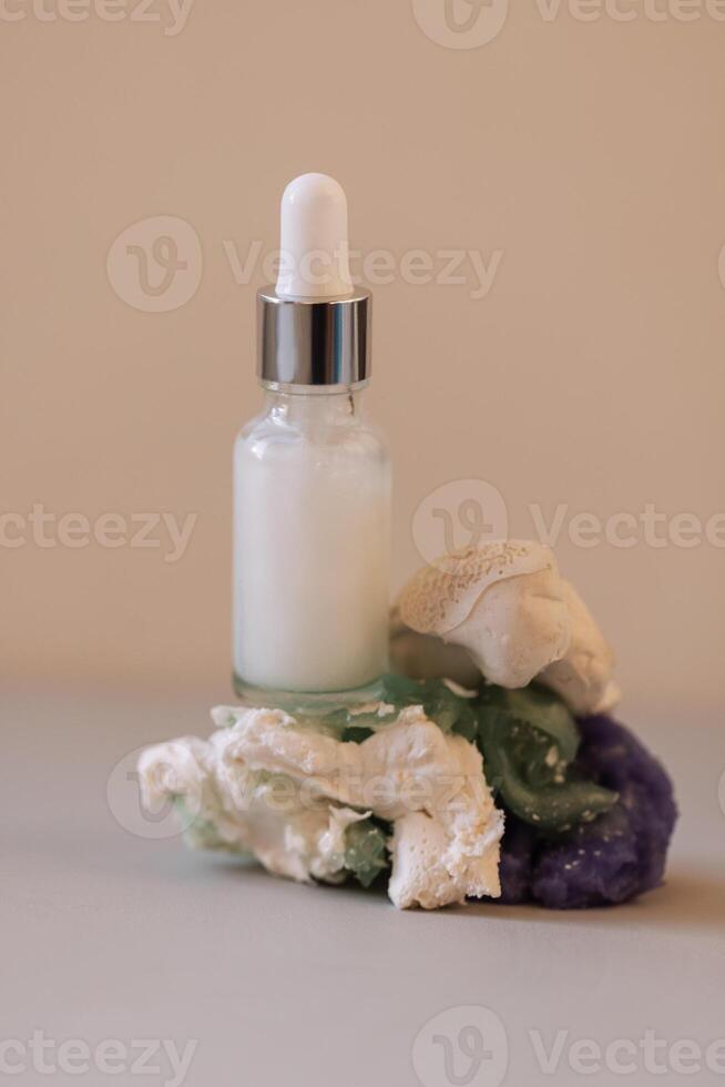 A close-up of a white glass bottle with a dropper with a moisturizing serum with bubbles photo