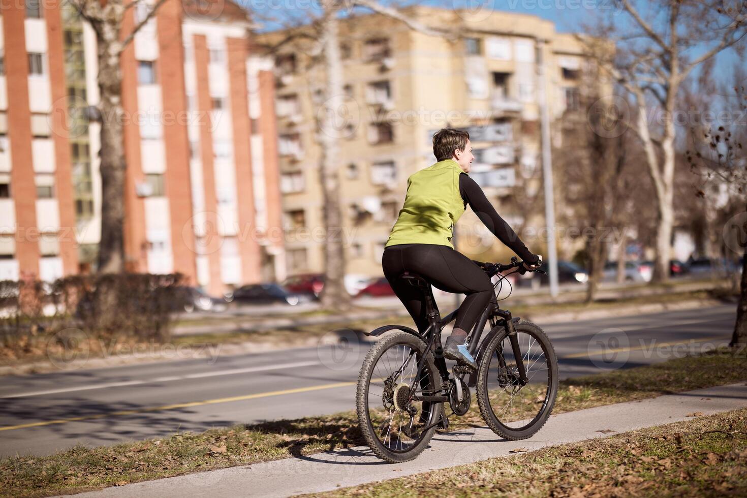 Midle Age Woman Riding Bike Down Street photo