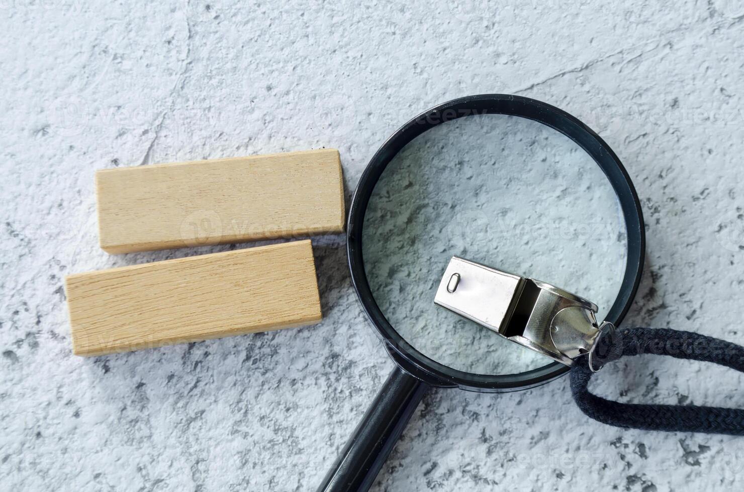 Magnifying glass and whistle with customizable space on wooden block for text photo