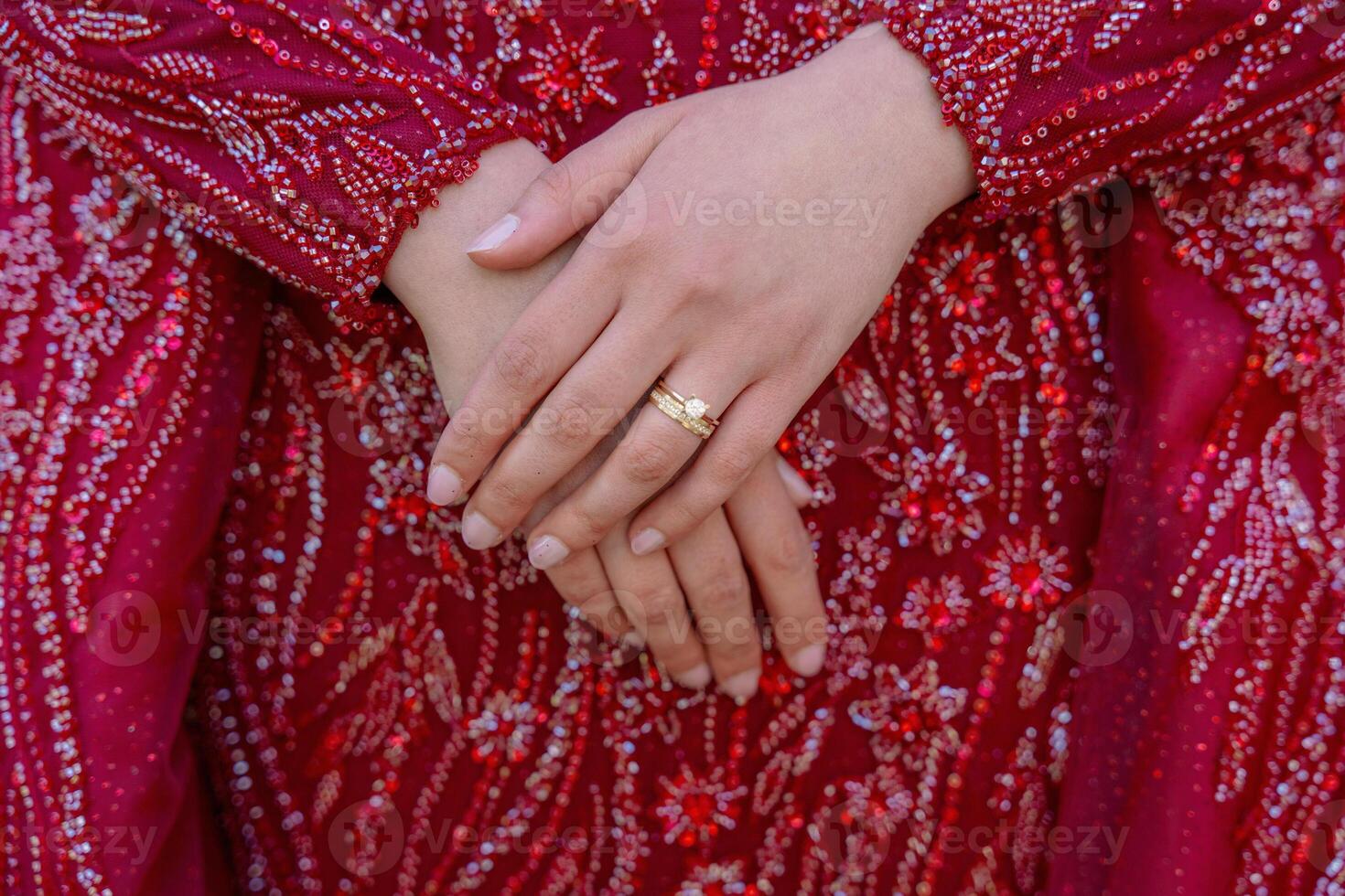 Close-up of Hands with Wedding Ring on Red Dress photo