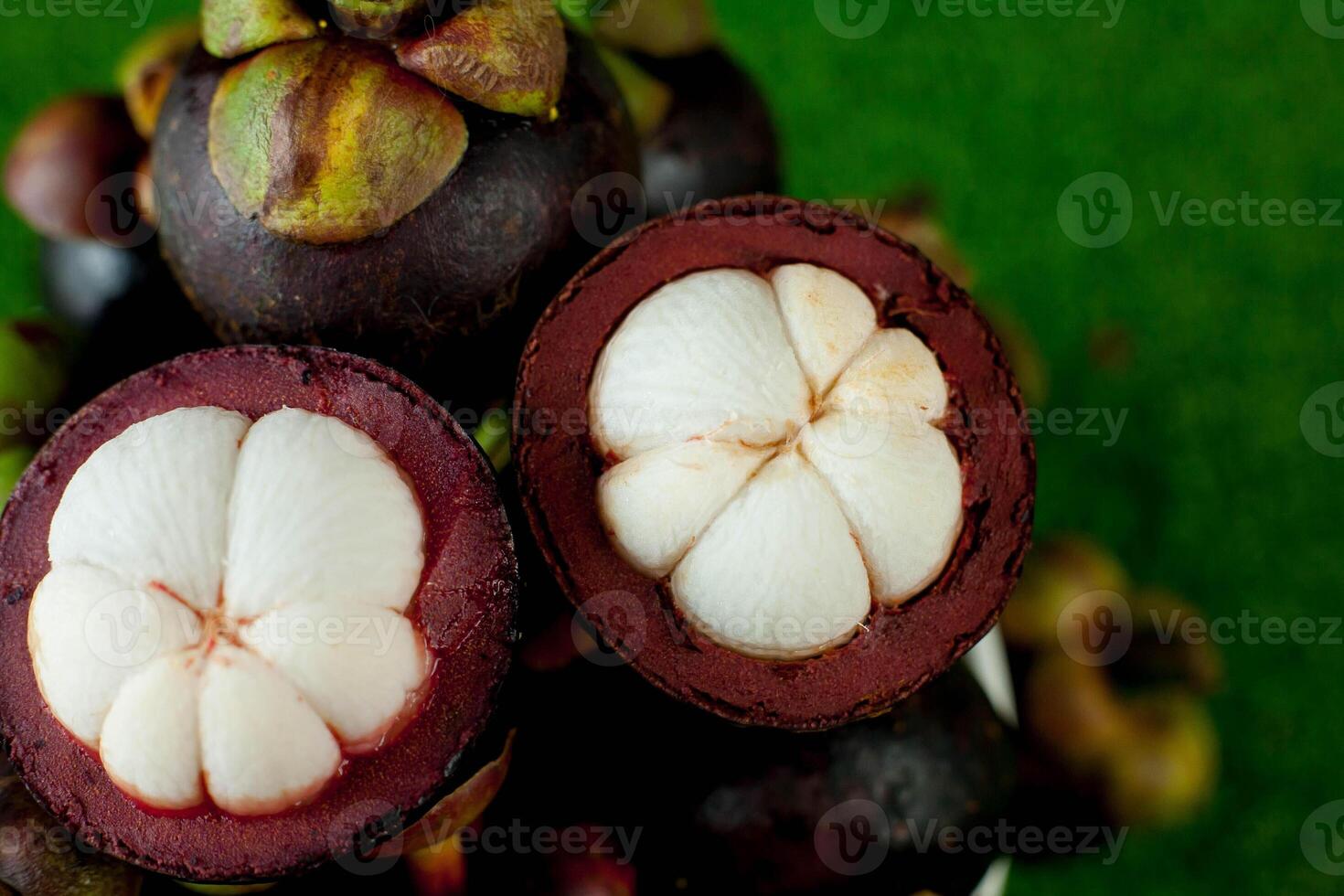 11 Fresh mangosteen fruits and cross section showing the thick purple skin and white flesh. photo