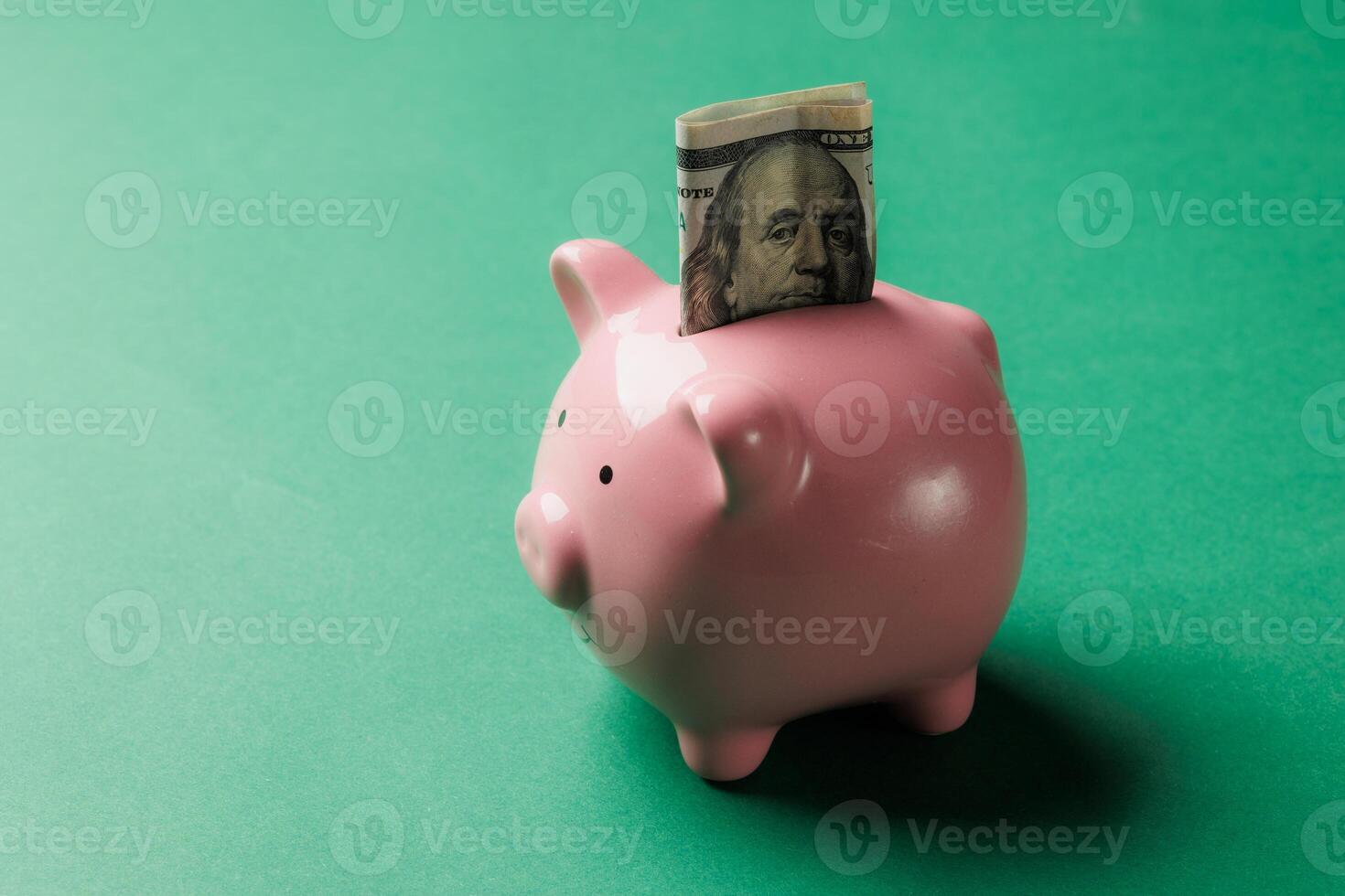 Piggy bank with cash placed on a green background highlighting saving money and financial management concepts photo