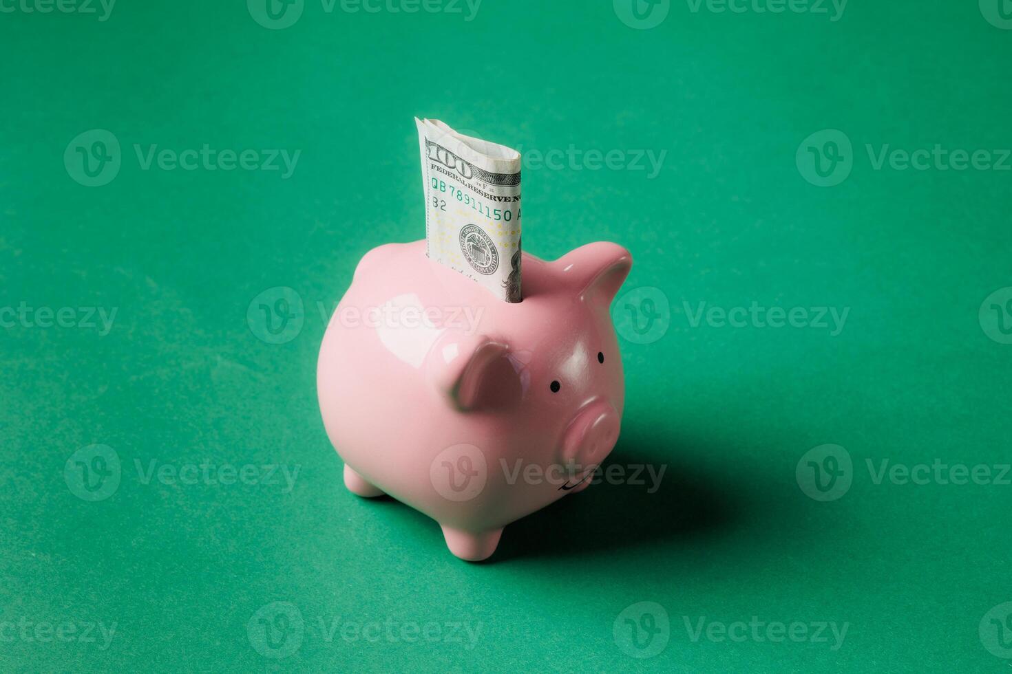 Piggy bank with dollar bill inserted on a bright green background illustrating savings concept photo