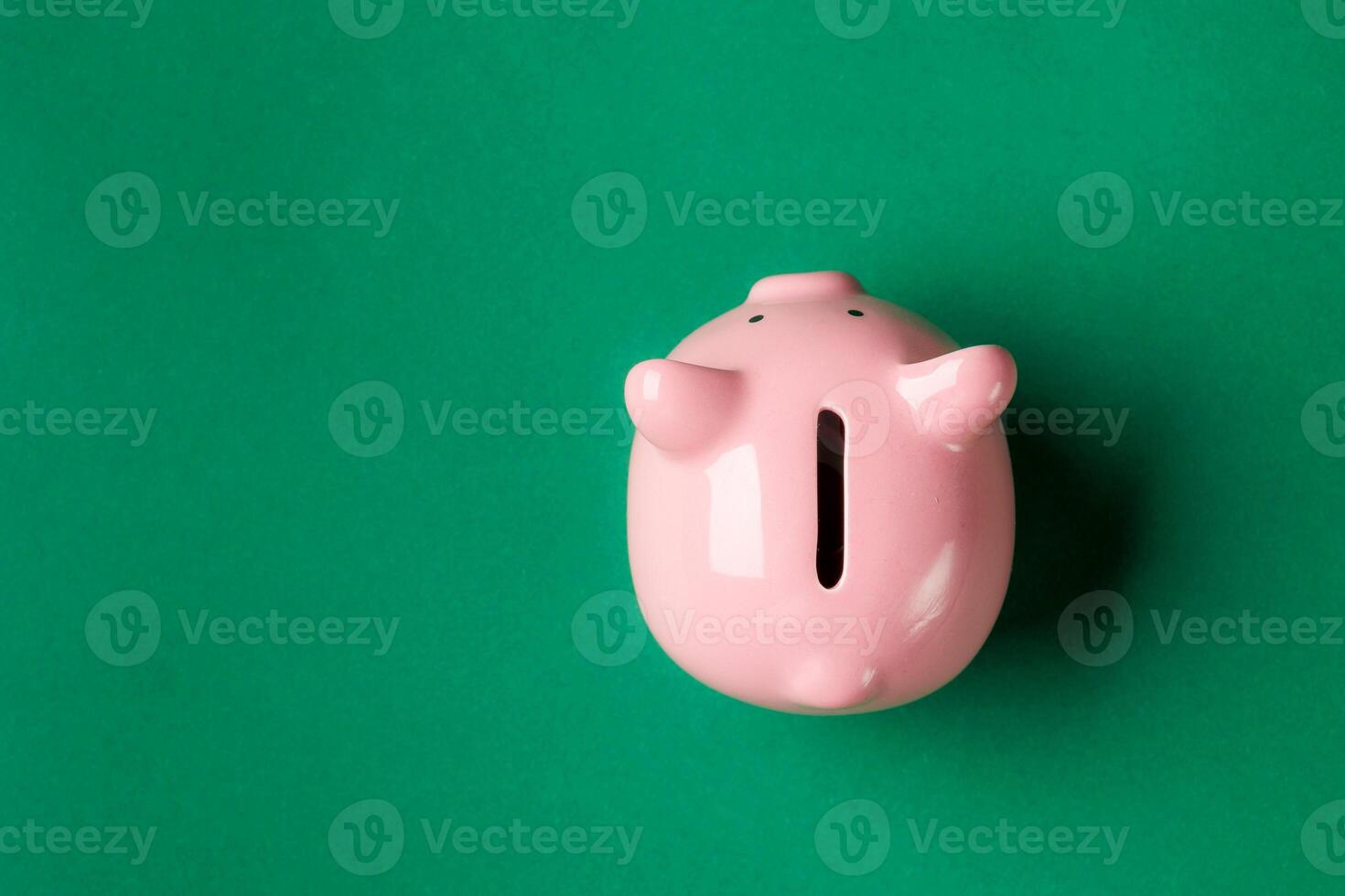 Ceramic piggy bank on a green background used for saving money and teaching financial responsibility photo