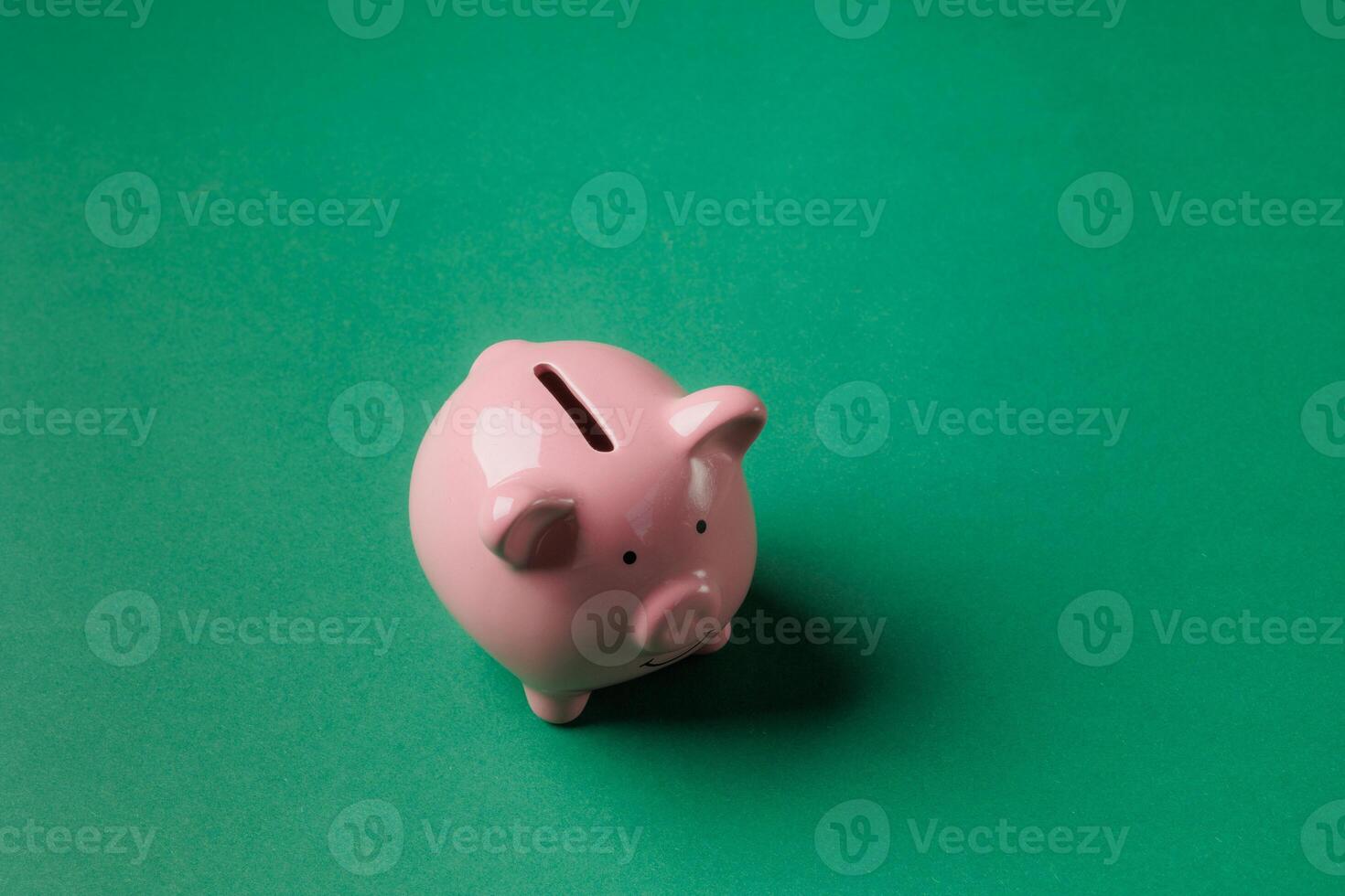 Piggy bank sits on green surface, symbolizing savings and financial planning for future goals and aspirations photo