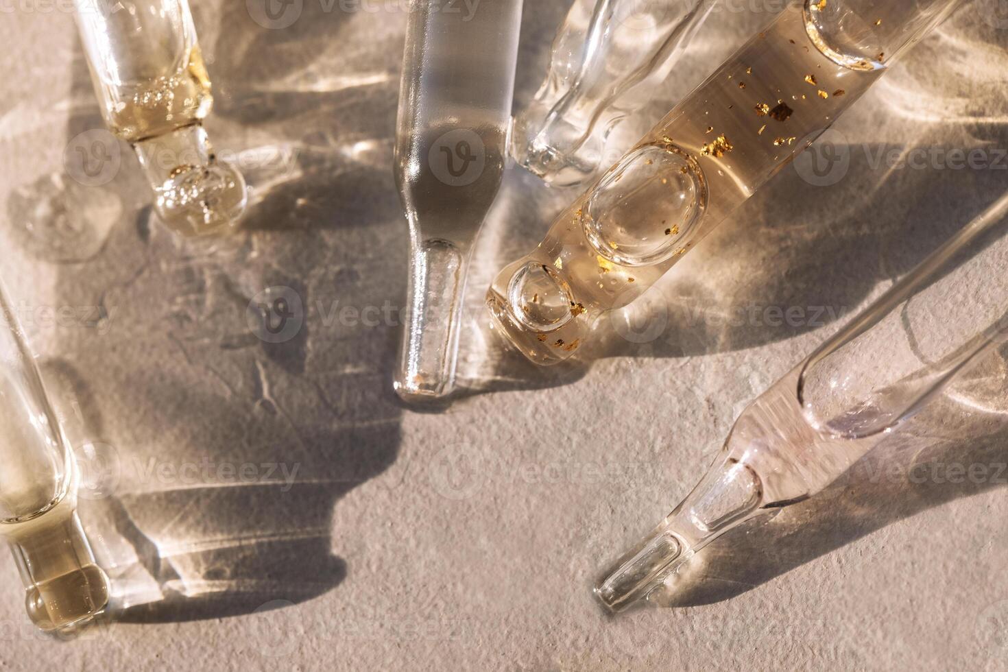 Close up of glass pipettes with moisturizing serum with colloidal gold. photo