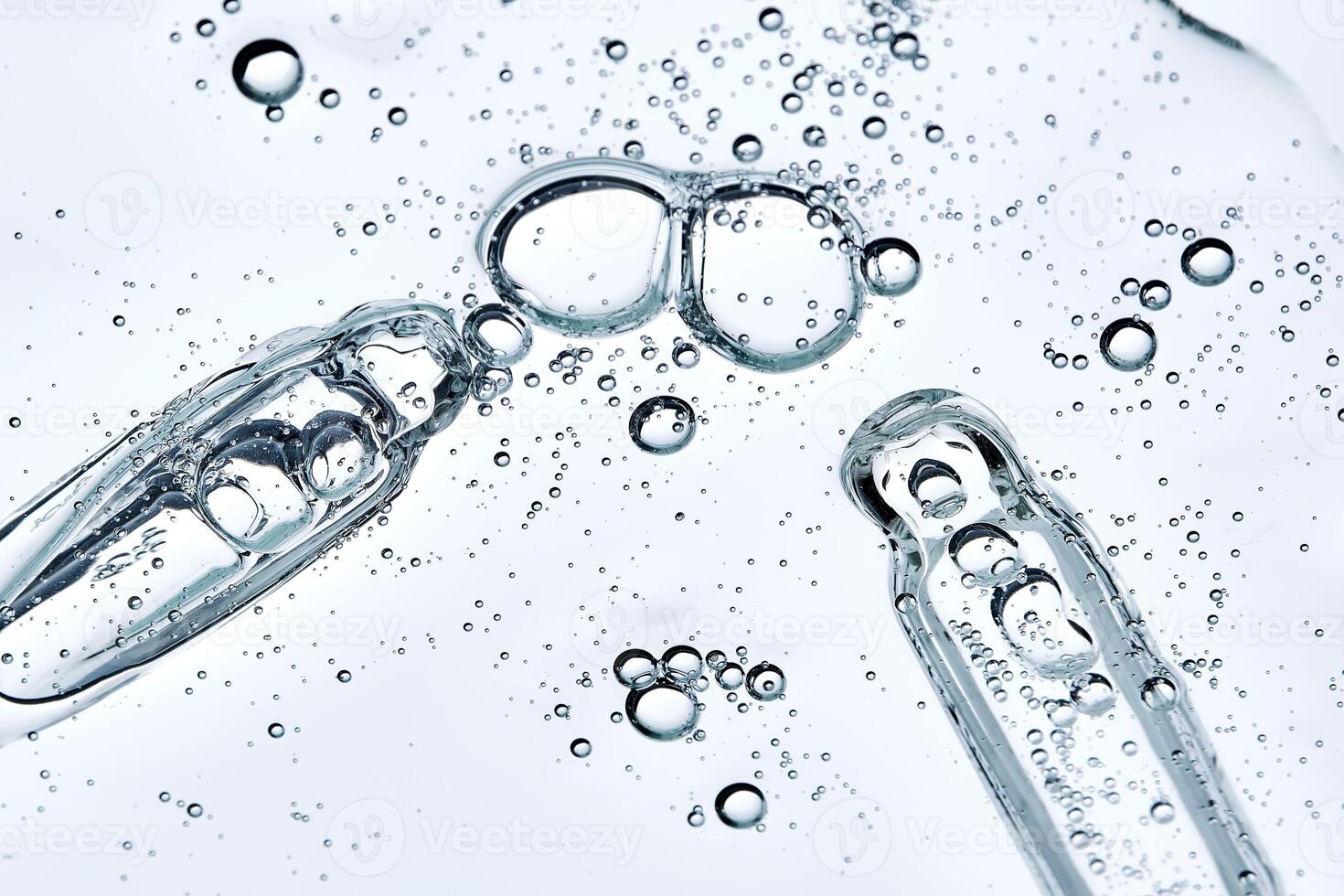 Two pipettes with thick hyaluronic serum with bubbles. Angle from below. photo