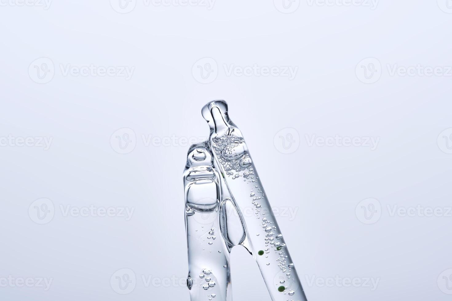 Two different face serum pipettes on a neutral background. photo