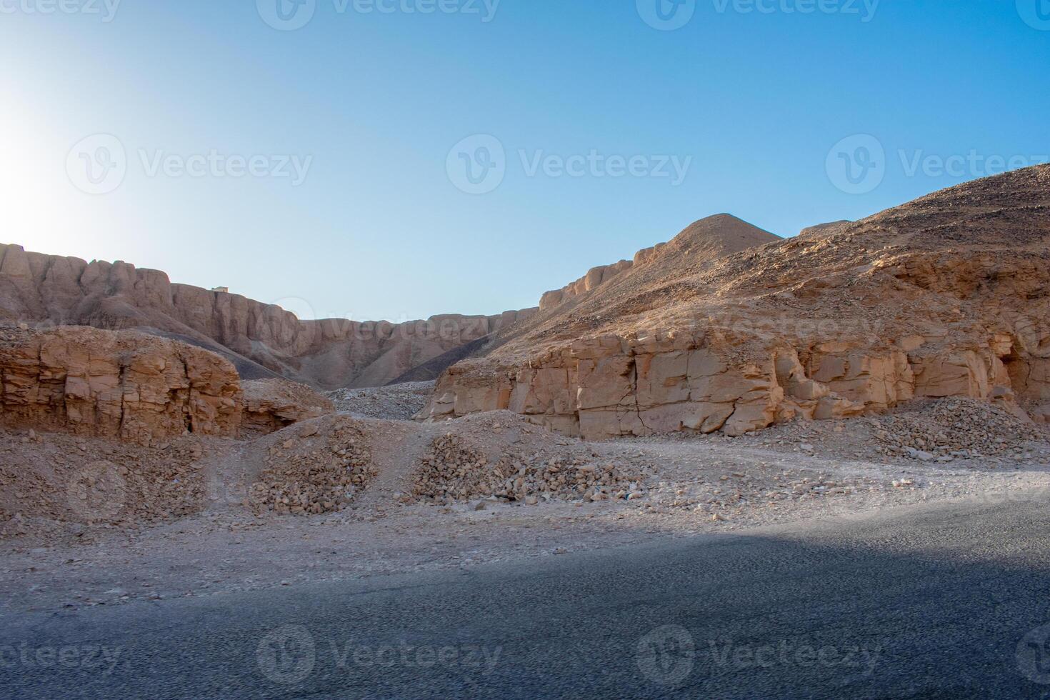 Rock formations beside road, against blue sky. Luxor, Valley of the Kings, Egypt photo