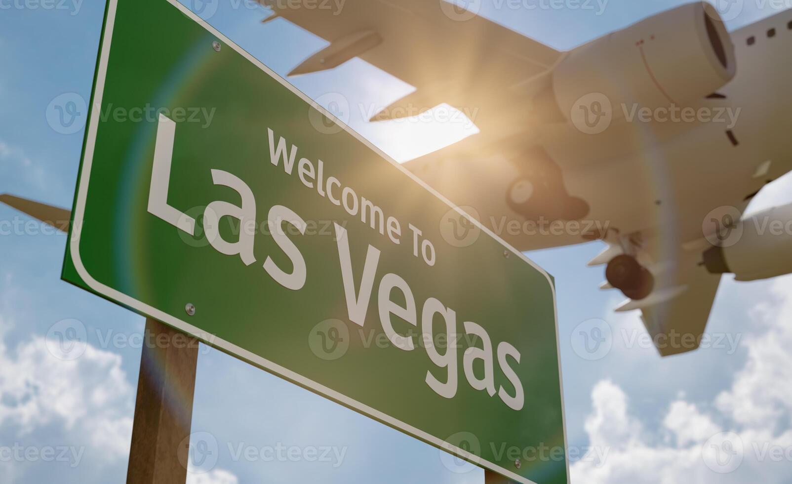 Welcome To Las Vegas Green Road Sign with Low Flying Airplane Just Above with Landing Gear Down. photo