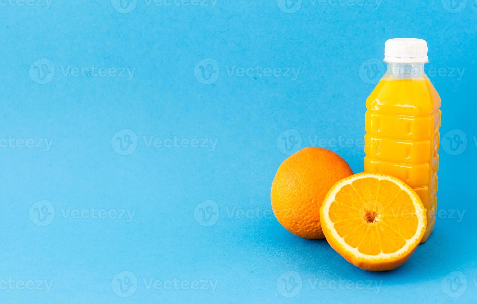 Natural wooden kitchen setup with fresh oranges and plants reflecting eco lifestyle and mindful slow living Minimal composition with fresh orange juice bottle and citrus fruit on bright blue backgroun photo
