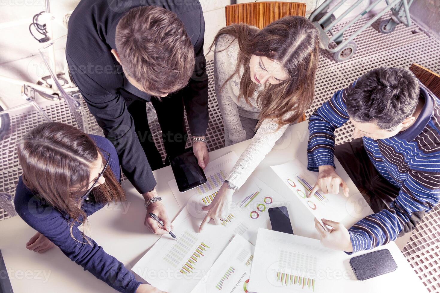 a team of young successful business people in informal clothes consulting charts in an office photo