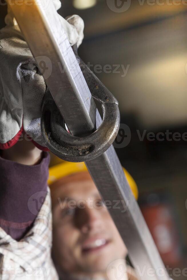 metalworker in a work environment hooking a steel pipe photo