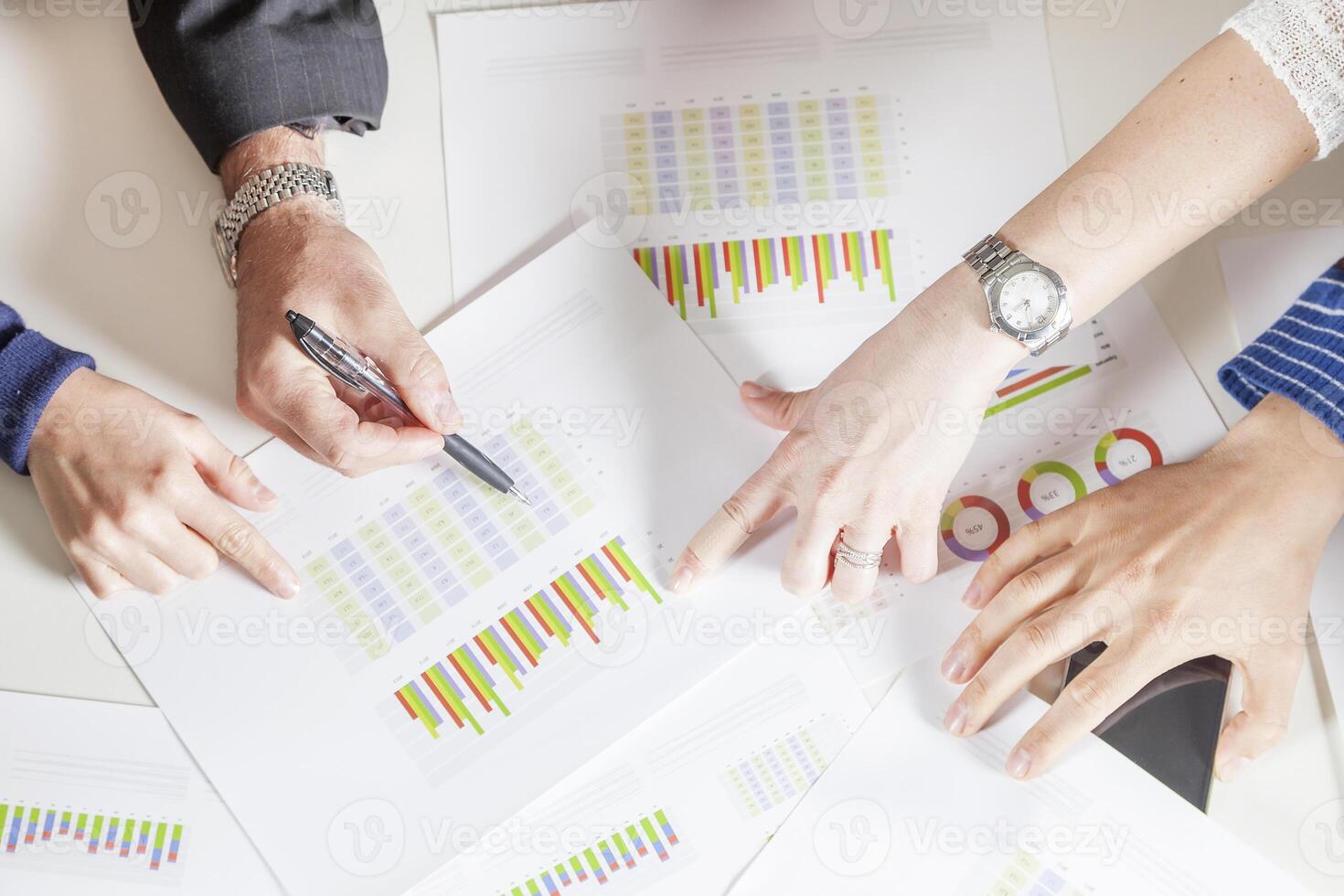 close up of hands of young successful business people consulting charts on a desk photo
