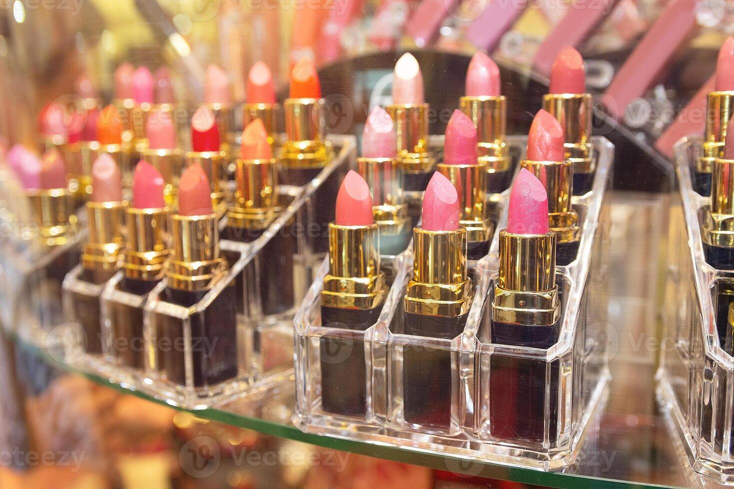 Array of lipstick sticks in various shades housed in golden casing photo