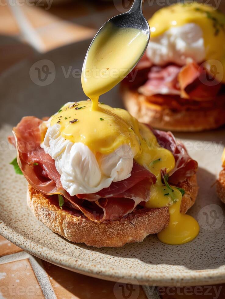 Realistic food photography in film style toast with prosciutto, leafy greens, and poached egg, topped with thick hollandaise sauce being drizzled from a spoon. photo