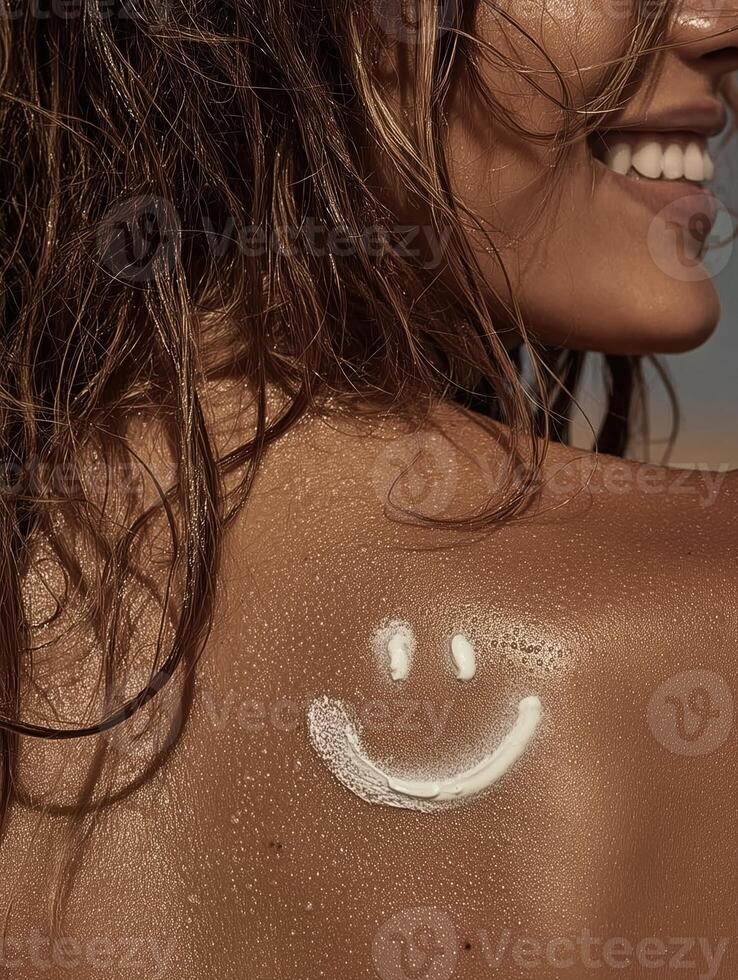 Close-up of a tanned back with a playful smiley face drawn using white sunscreen. Hair is slightly wet, and the skin glows in the sun. photo
