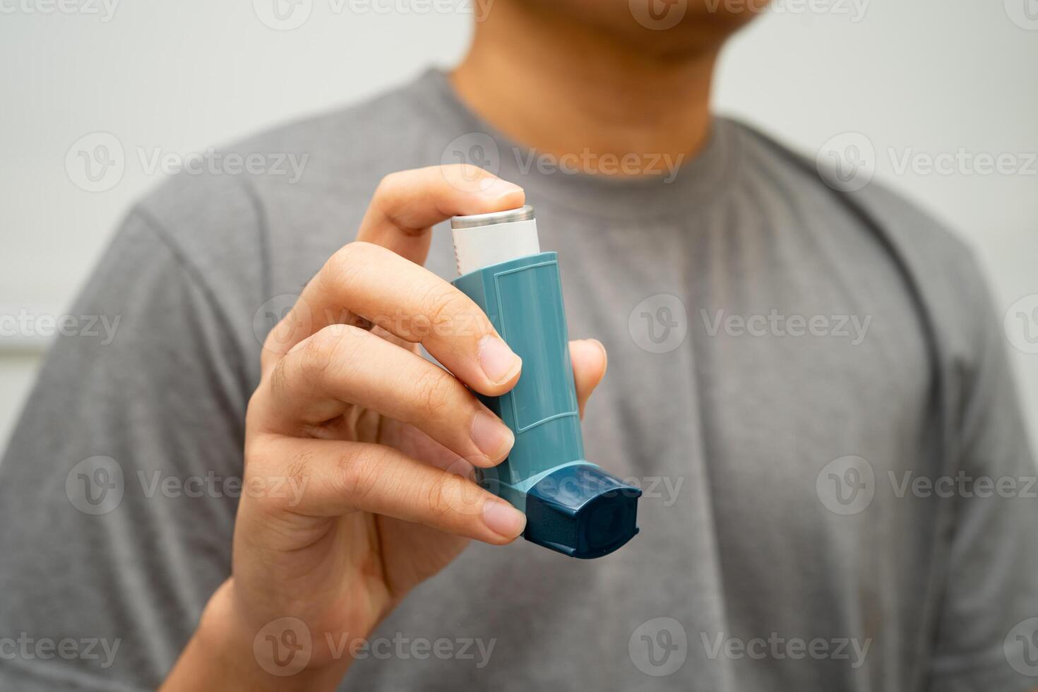 Asthma and chronic obstructive pulmonary disease COPD, Asian young man using metered photo