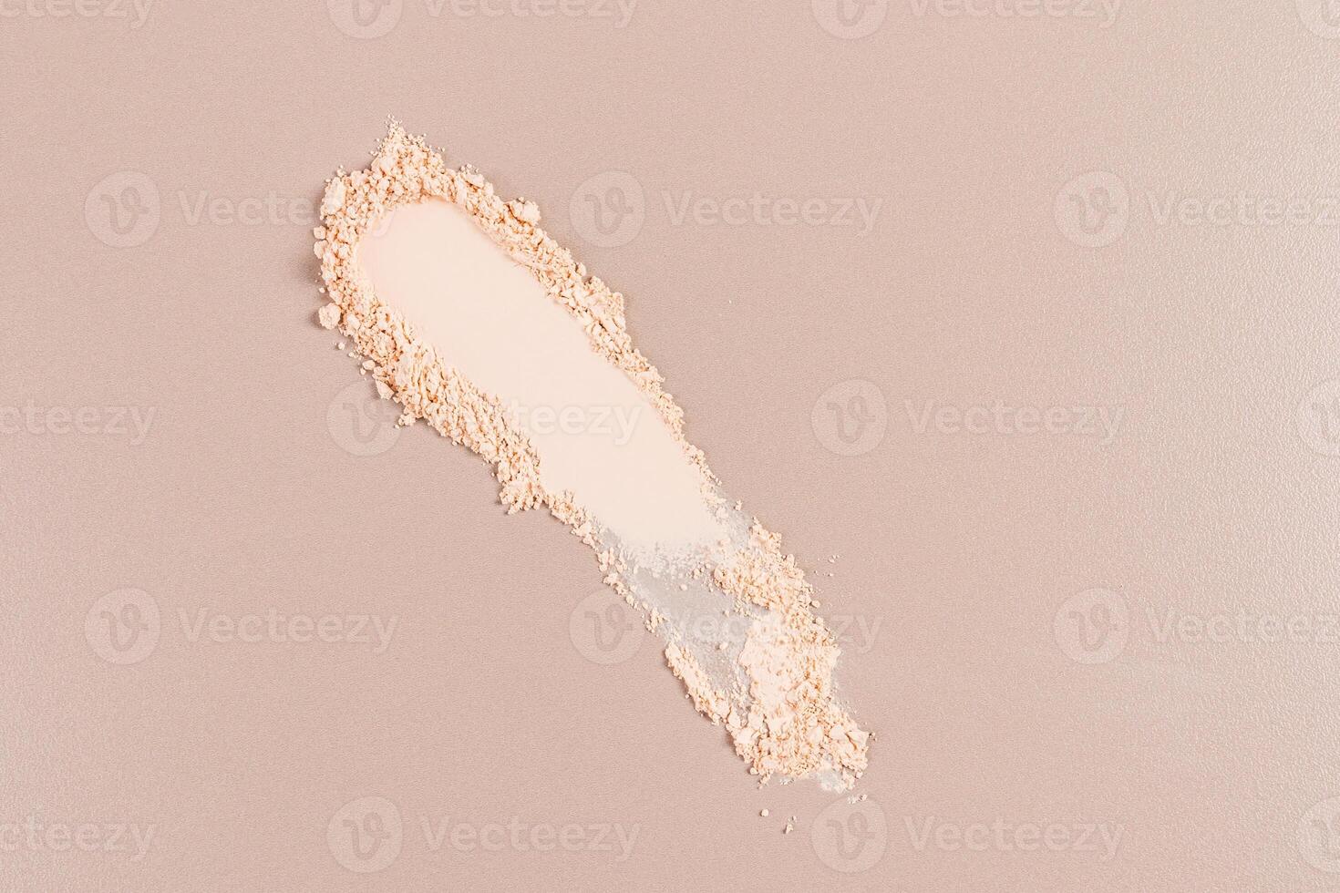 A beautiful sample texture of a dry compact powder in a natural tone on a beige background. top view. A copy space. layout product for advertising photo