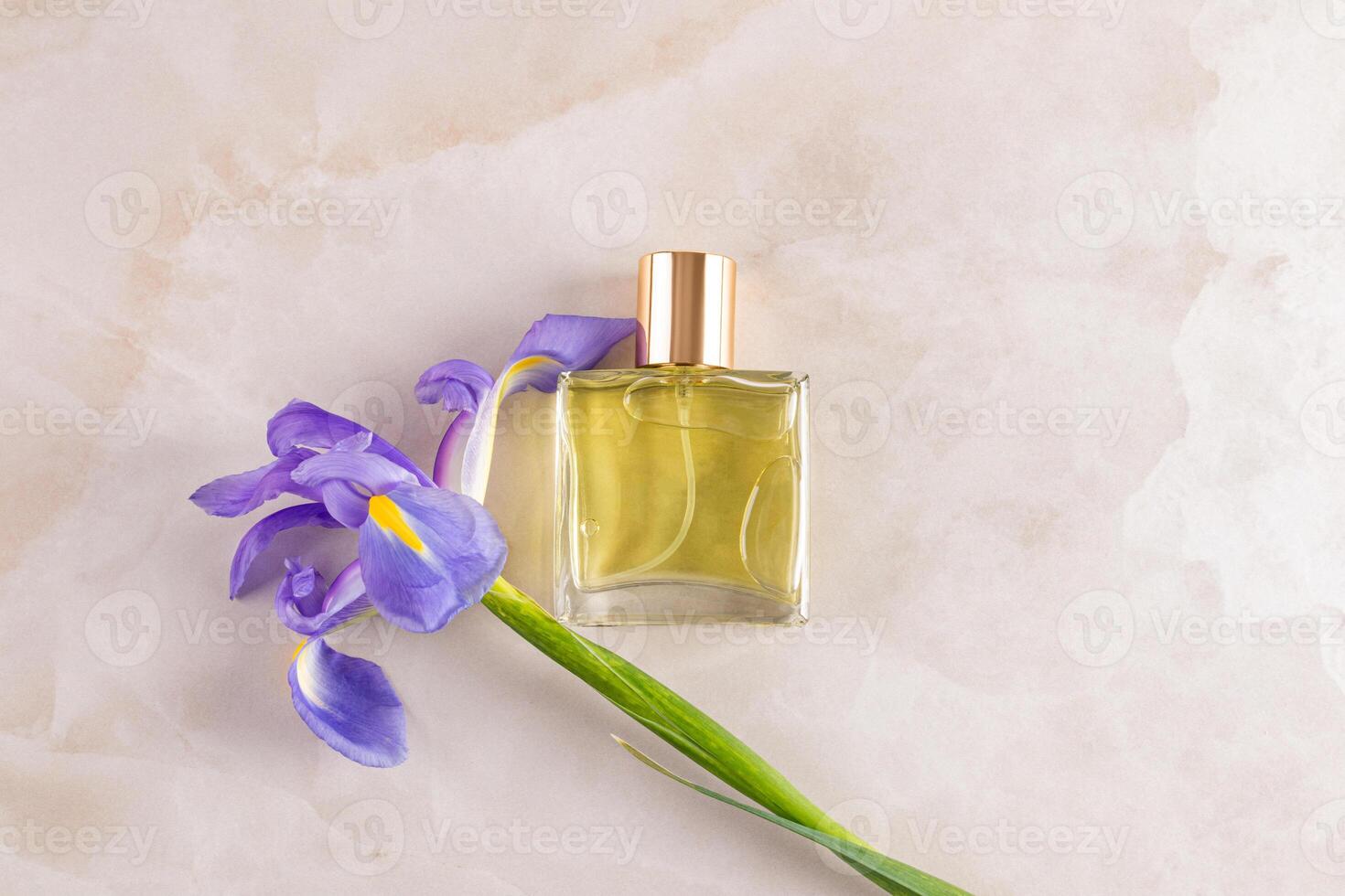 An elegant bottle of cosmetic spray or perfume with a delicate floral aroma, notes of iris on a beige background. top view. A blank bottle mockup photo
