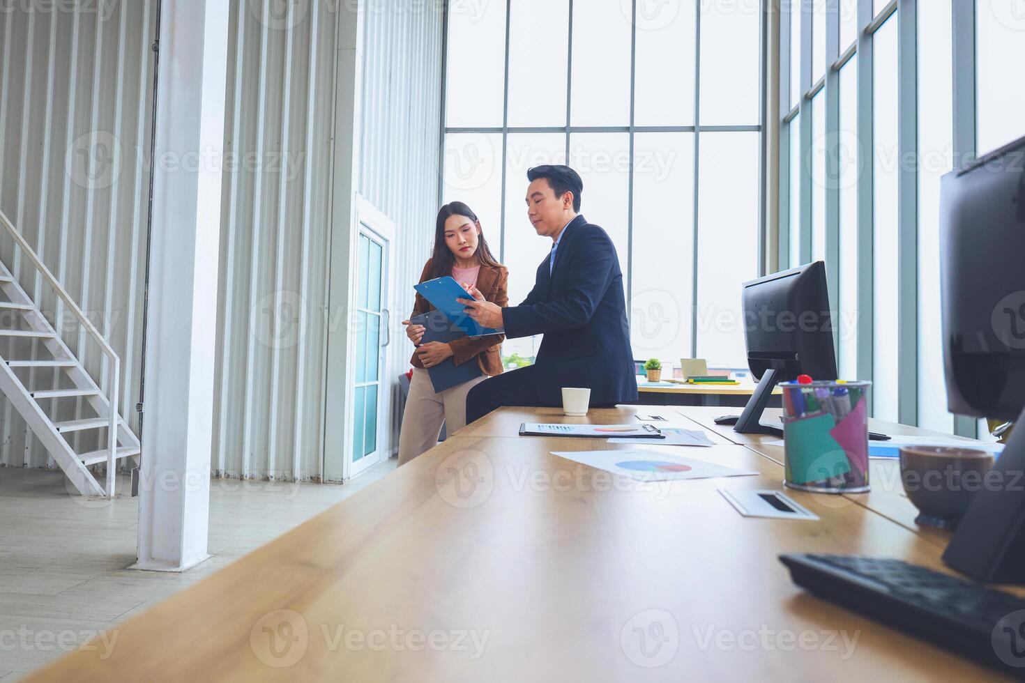Two business professionals discussing documents in modern office, Team meeting and brainstorming concepts photo