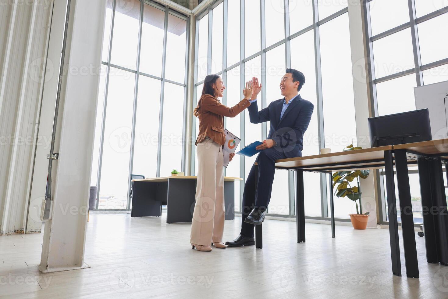 Business people greeting in office, Cheerful business team celebrating success in modern office, Team meeting and brainstorming concepts photo