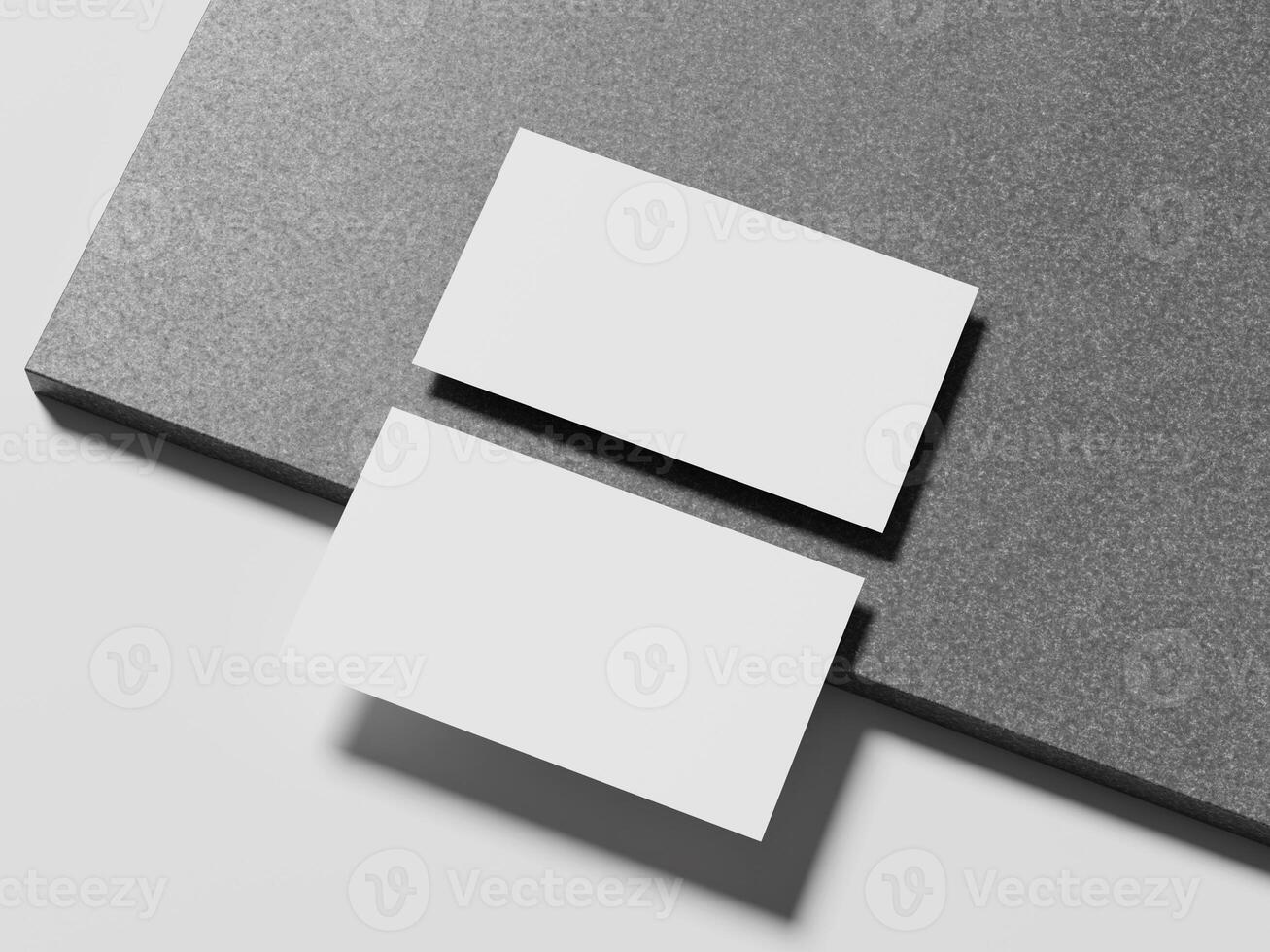 A pair of simple white business cards positioned on a smooth marble surface, casting a subtle shadow for an elegant presentation. photo