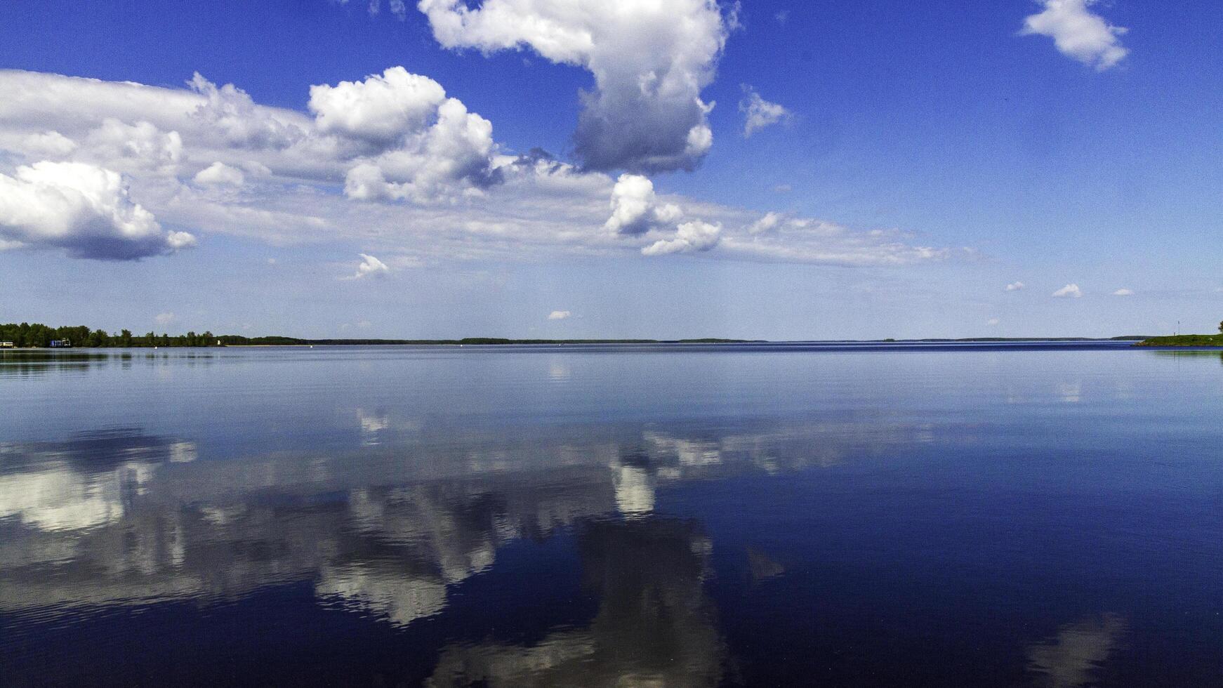 Mirror lake with reflections of the sky and clouds on a sunny day. photo