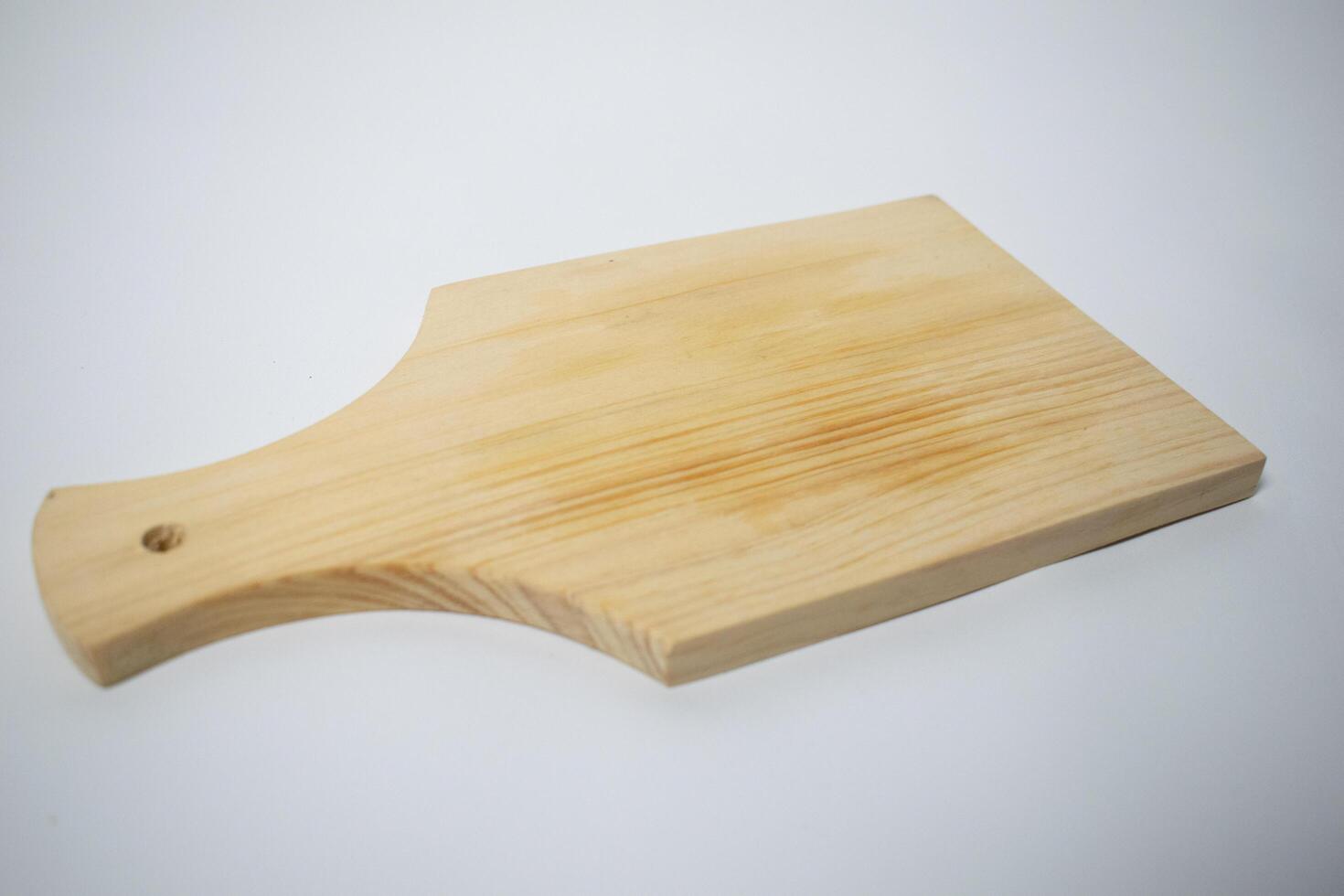 A plain wooden cutting board with a smooth surface and light wood grain, perfect for kitchen use. photo