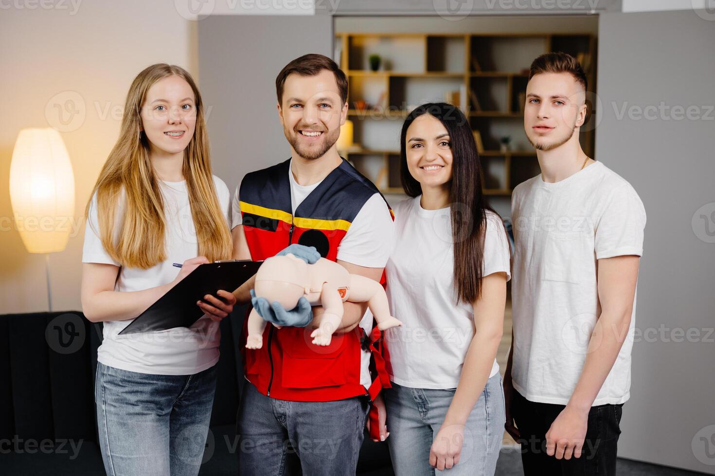 Group of people learning how to make first aid with dummy child during the training in room. photo