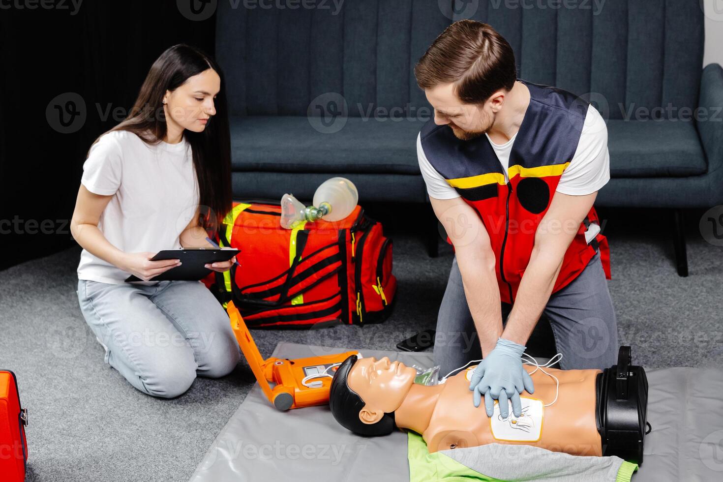 Instructor demonstrating cpr chest compression on a dummy in class photo