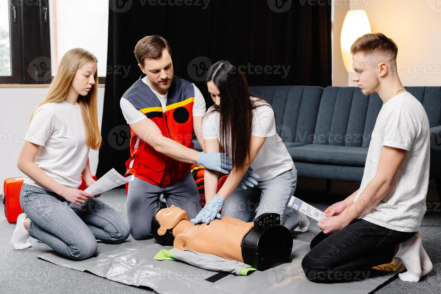 Group of people learning how to make first aid heart compressions with dummies during the training in class photo
