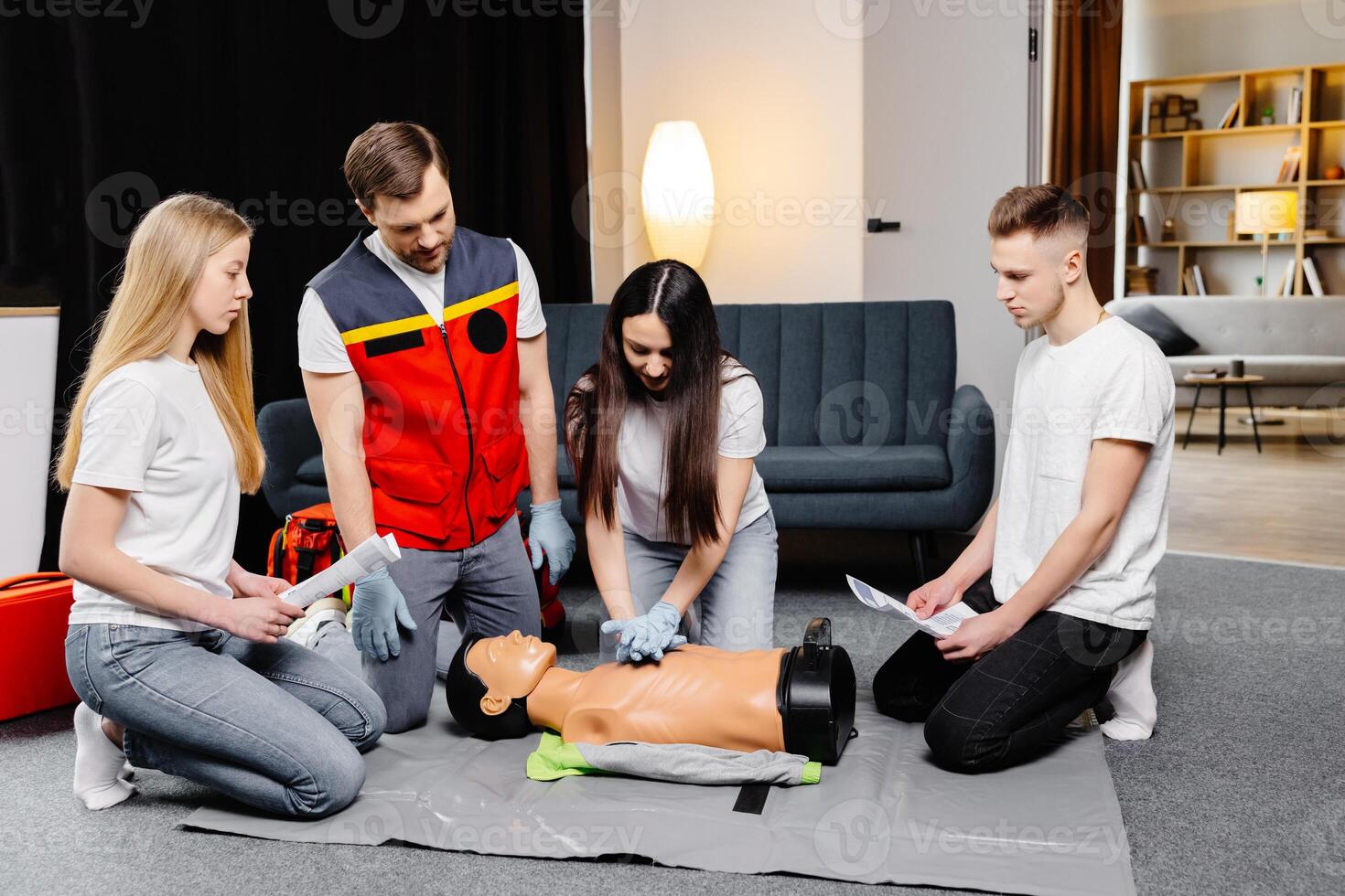 Group of people learning how to make first aid heart compressions with dummies during the training. photo