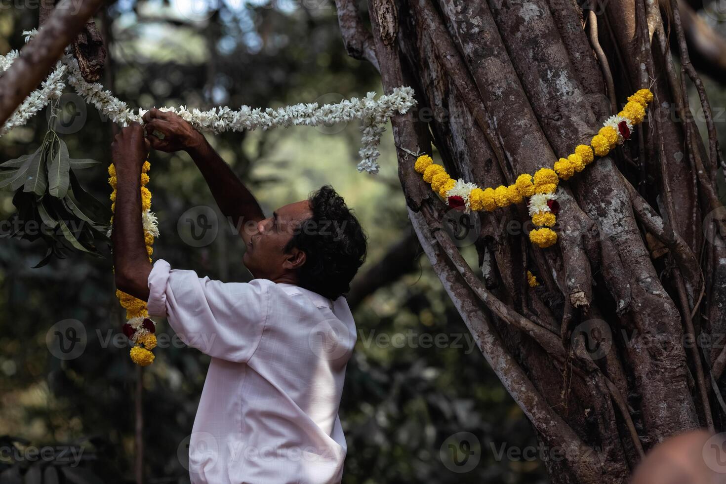 man helps to hang decorations before the wedding ceremony photo