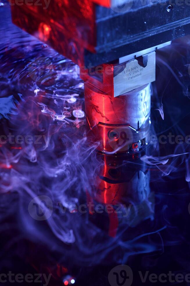 vertical view of the machine working on liquid with blue and red illumination photo