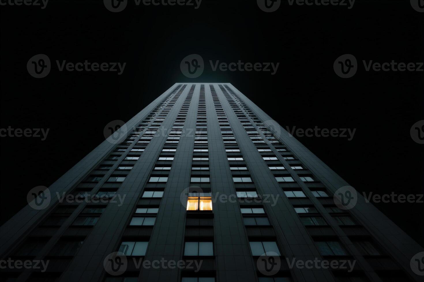 Urban night scene with glowing window in high-rise building against dark sky photo