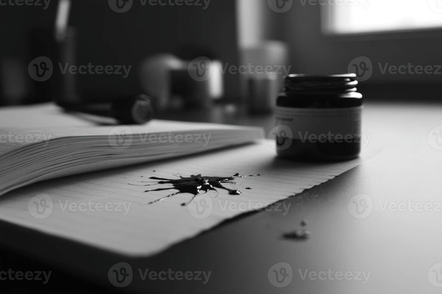 Ink splatter on open notebook beside ink jar on wooden desk in a creative workspace photo