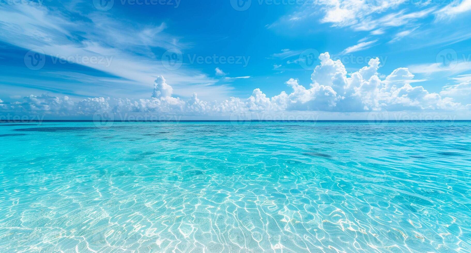 The blue ocean is calm and clear, with a few clouds in the sky photo