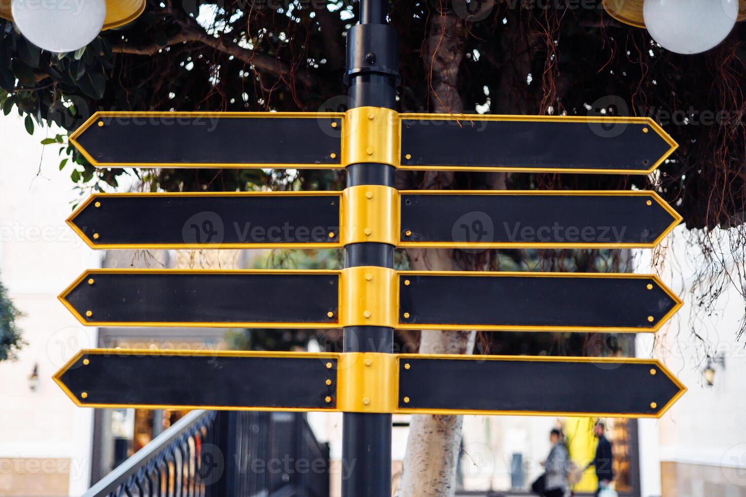 Directional signpost with multiple blank arrows in an urban setting during daylight hours. photo