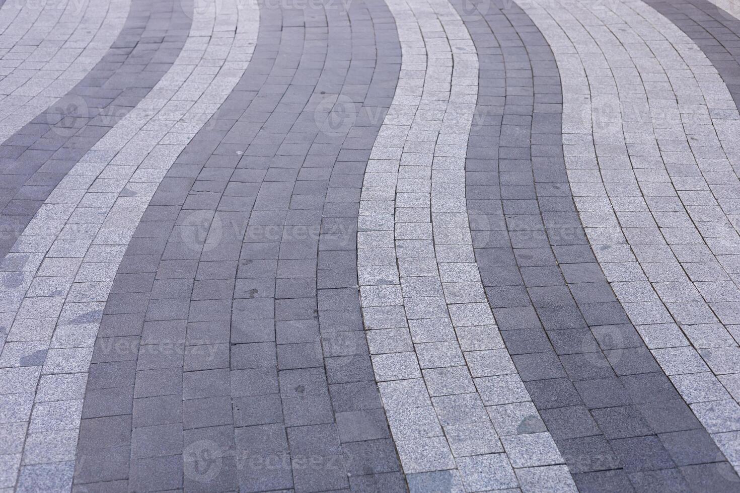 Unique wave patterns of paving stones create a striking urban walkway design. photo