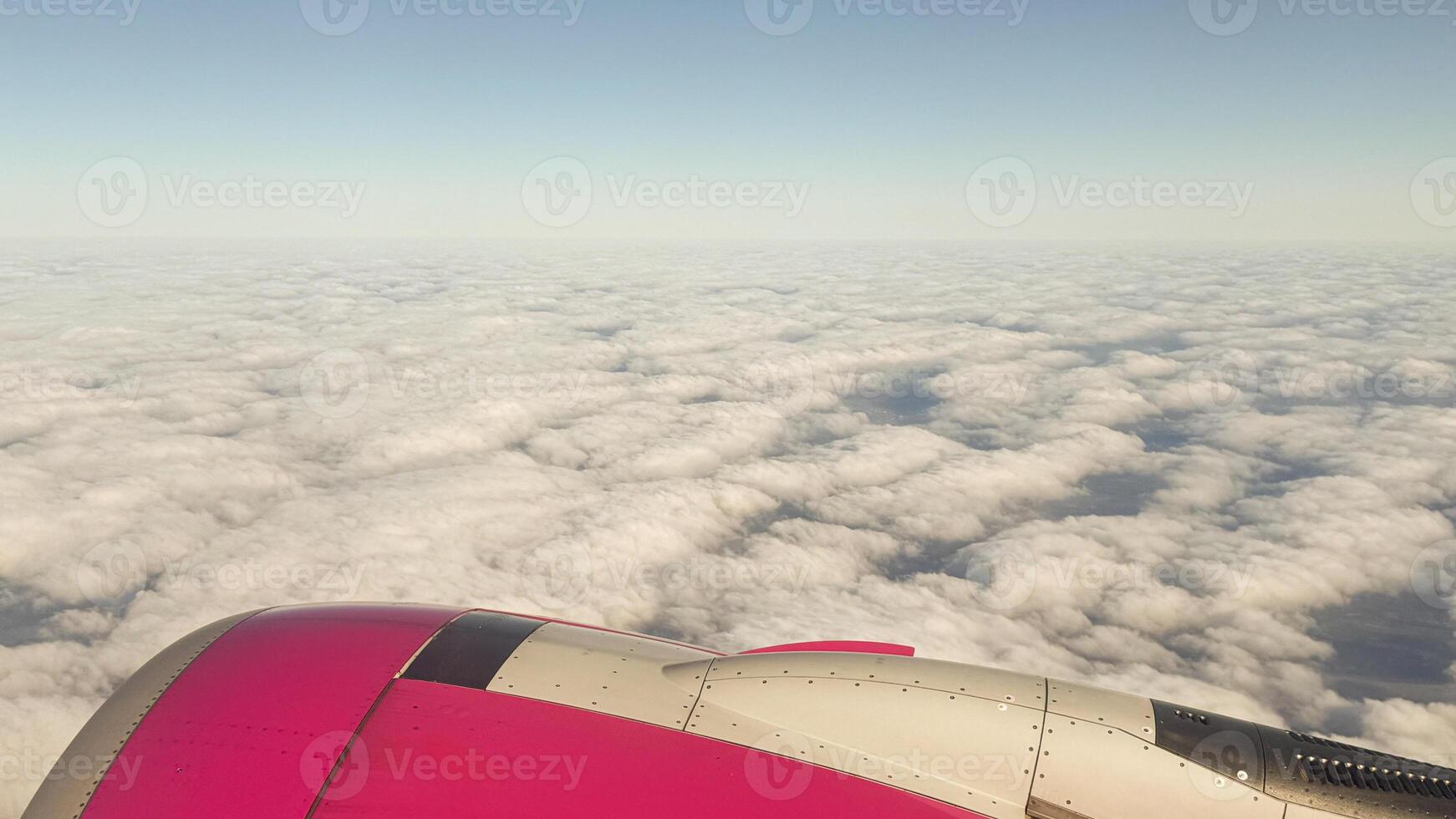Scenic view of airplane wing against expansive cloudscape during daytime flight through clear blue sky captured in mid-air journey photo